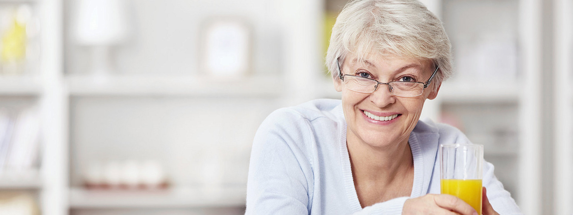 elderly woman holding a glass of juice